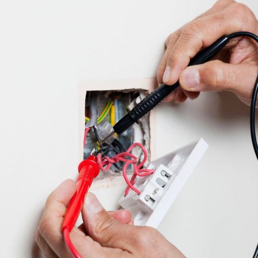 Electrician testing a socket outlet with a meter